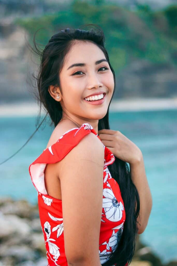Coverbild zum Artikel über Sugarbook mit einer Frau mit asiatischer Herkunft n einem roten Sommerkleid mit weißen Blume.