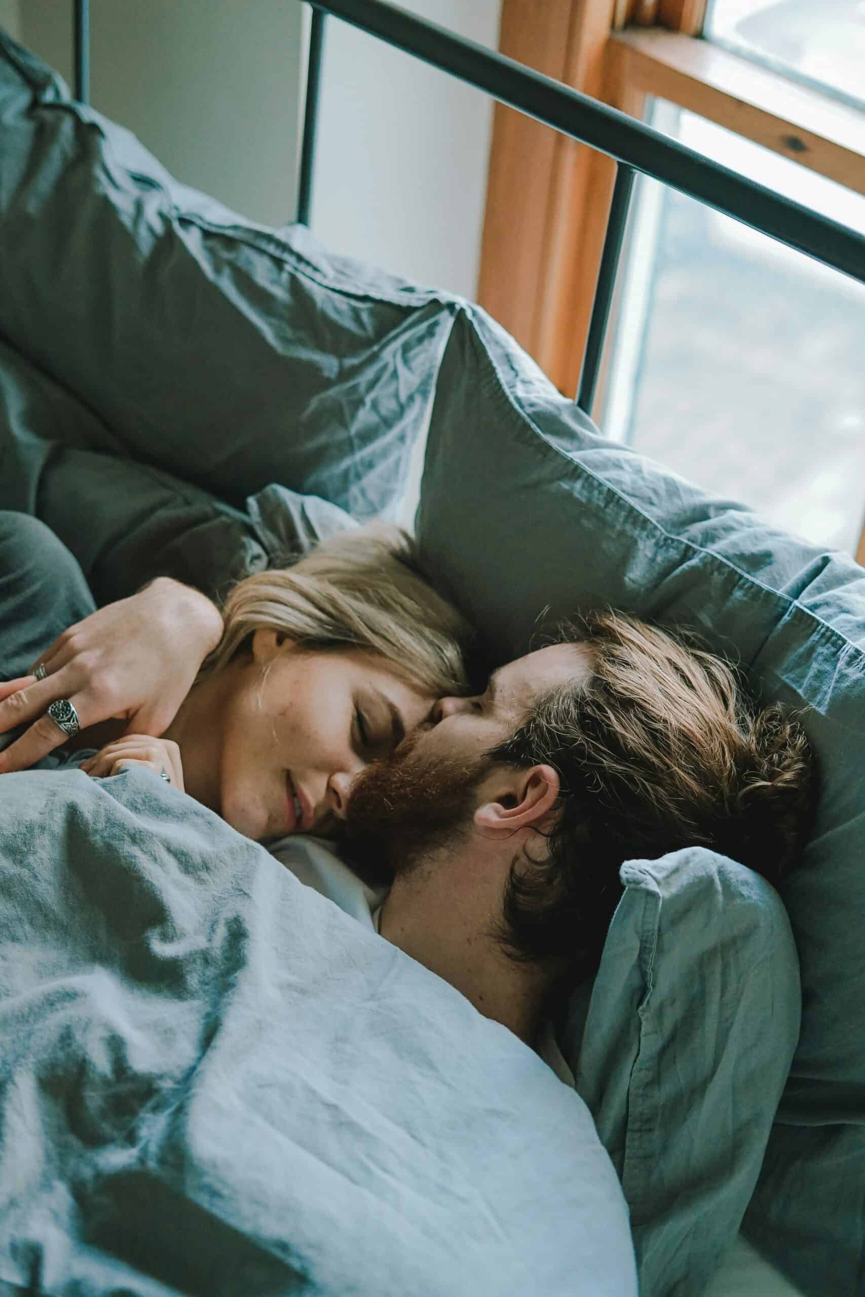 Ein glückliches Paar kuschelnd im Bett nach der Heilung einer Erektionsstörung